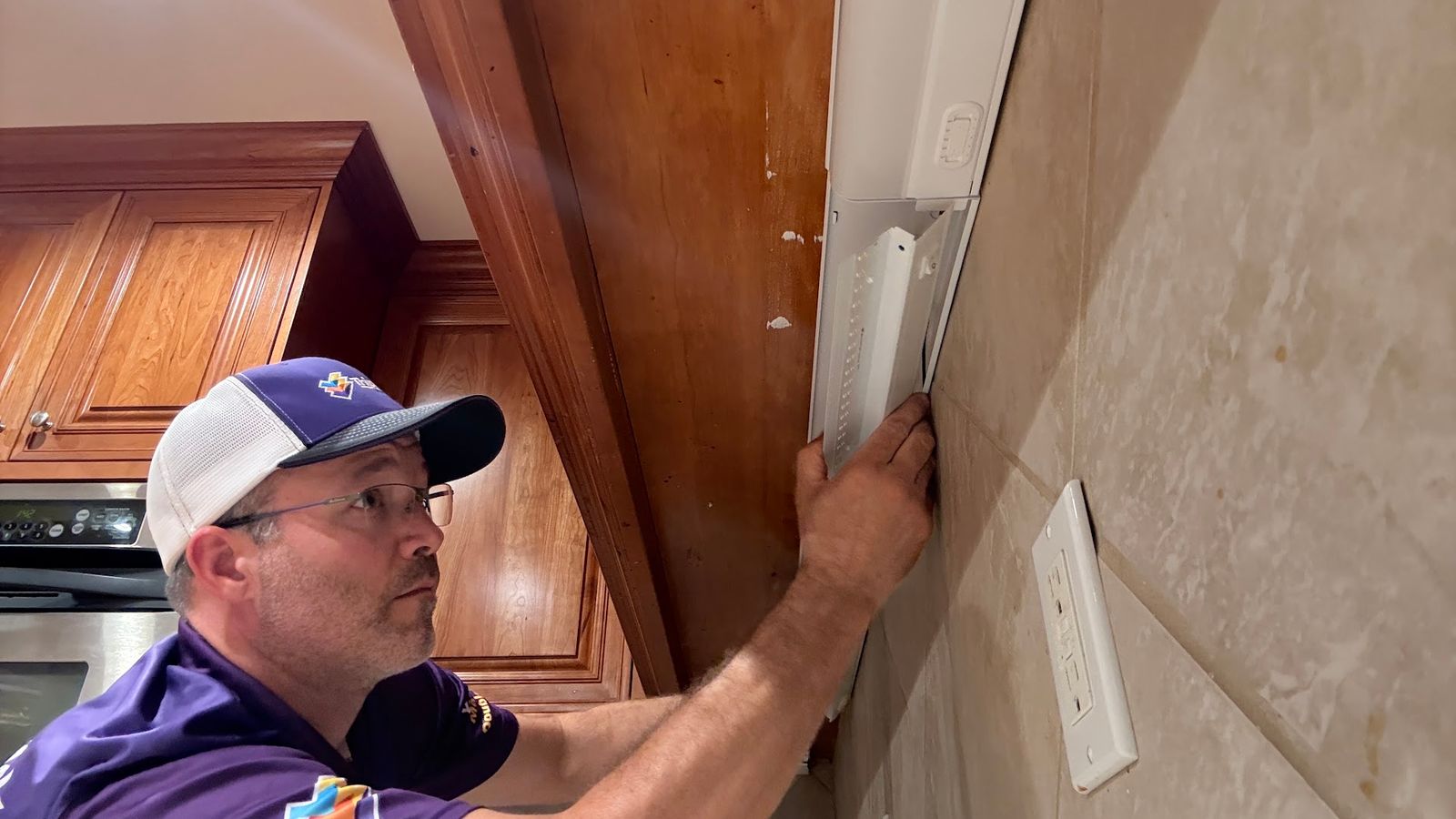 Mike Zagozda of Triple Check Electric repairing wiring in an Omaha home